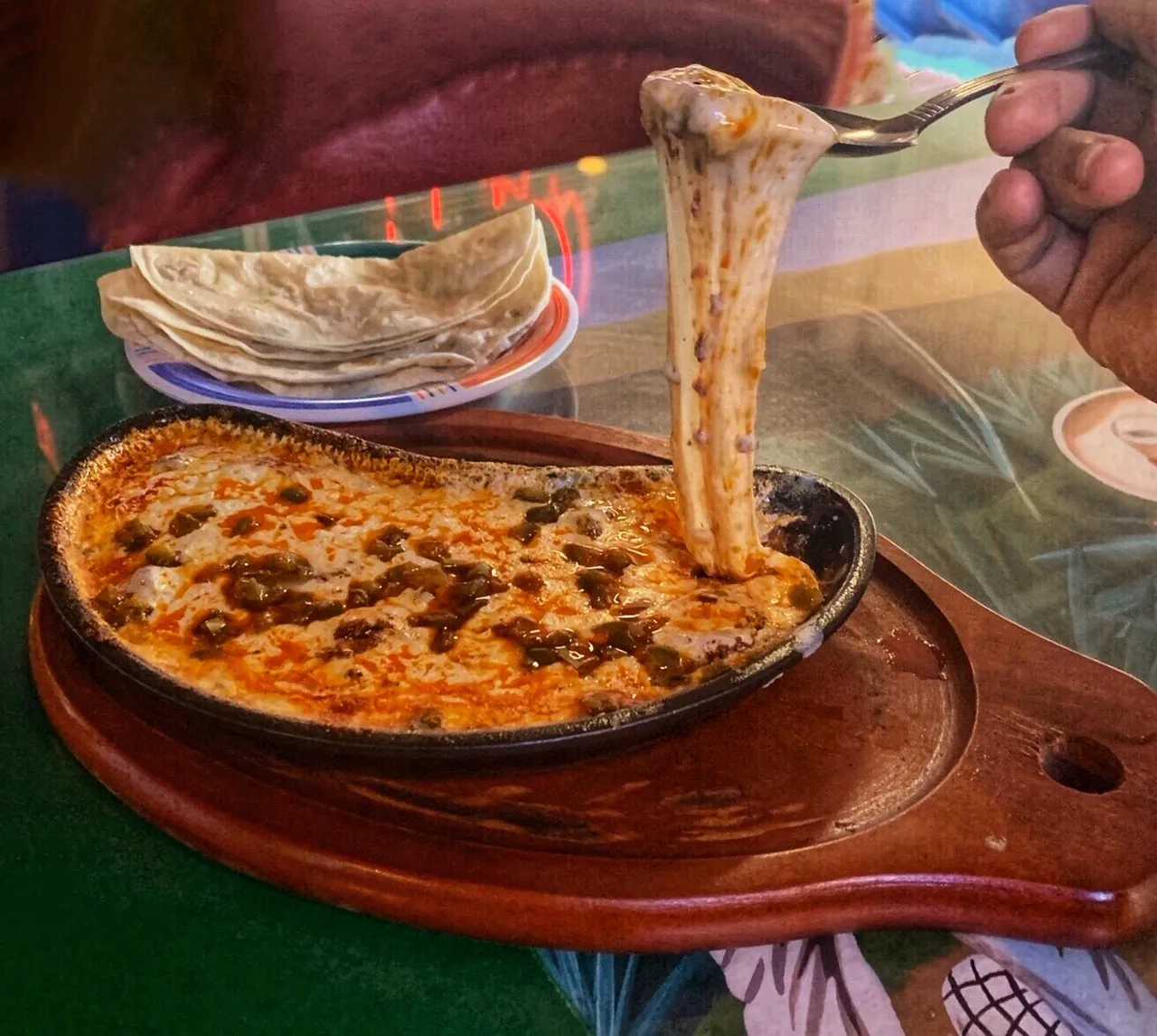 Queso fundido in a skillet with a cheese pull